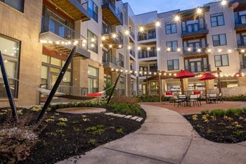 a courtyard with a hammock and patio furniture at the flats at big tex apartments in san  at Avant & Avant II, Carmel, IN, 46032